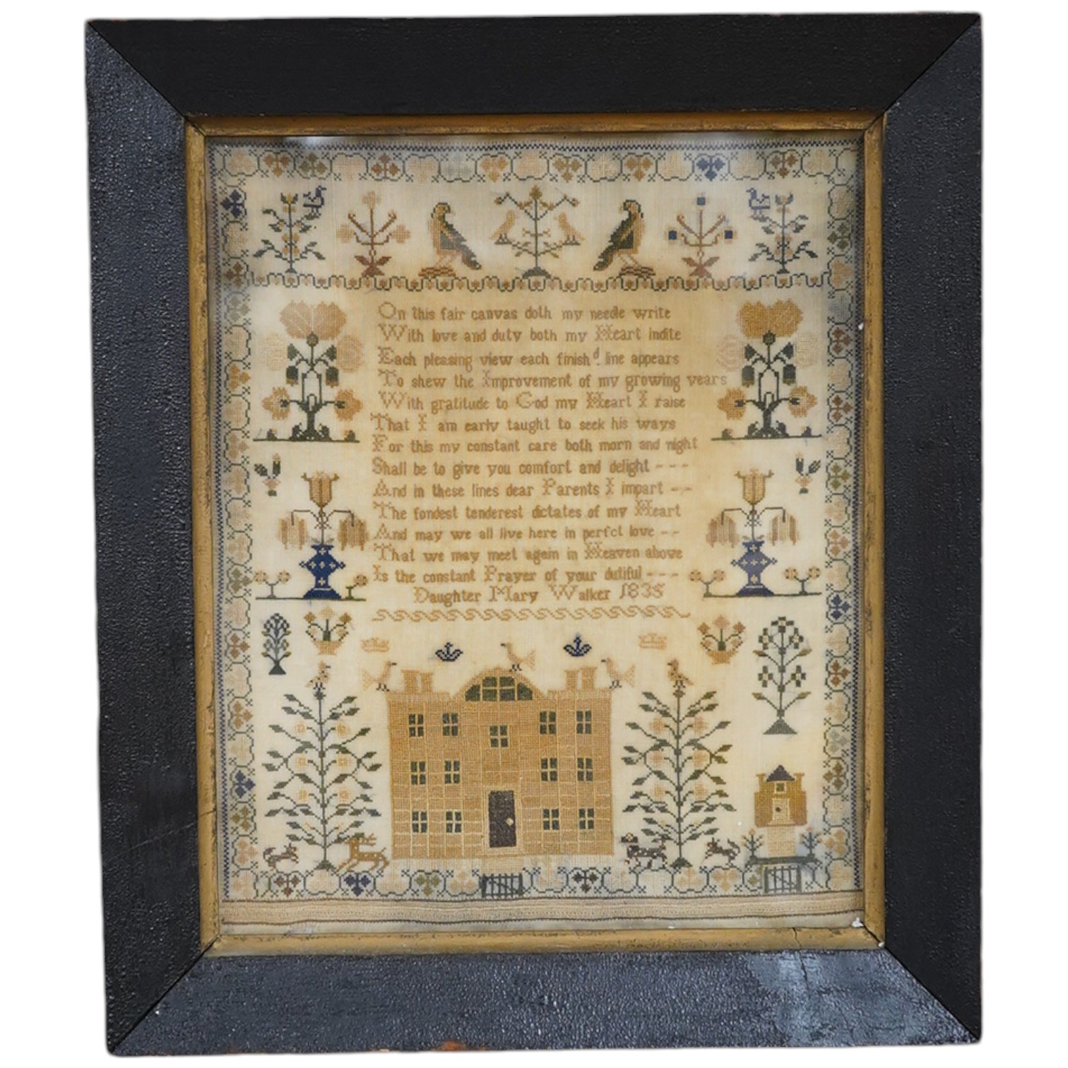 A framed 1835, dated sampler, embroidered by Mary Walker, worked in fine coloured silks, with a central verse and large three storey house, trees, dogs, deer and rabbits, below a panel of embroidered trees, flowers and b